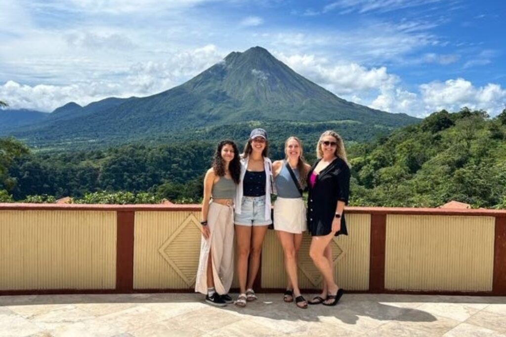 Group photo at Arenal Volcano viewpoint with tropical forest backdrop in Costa Rica